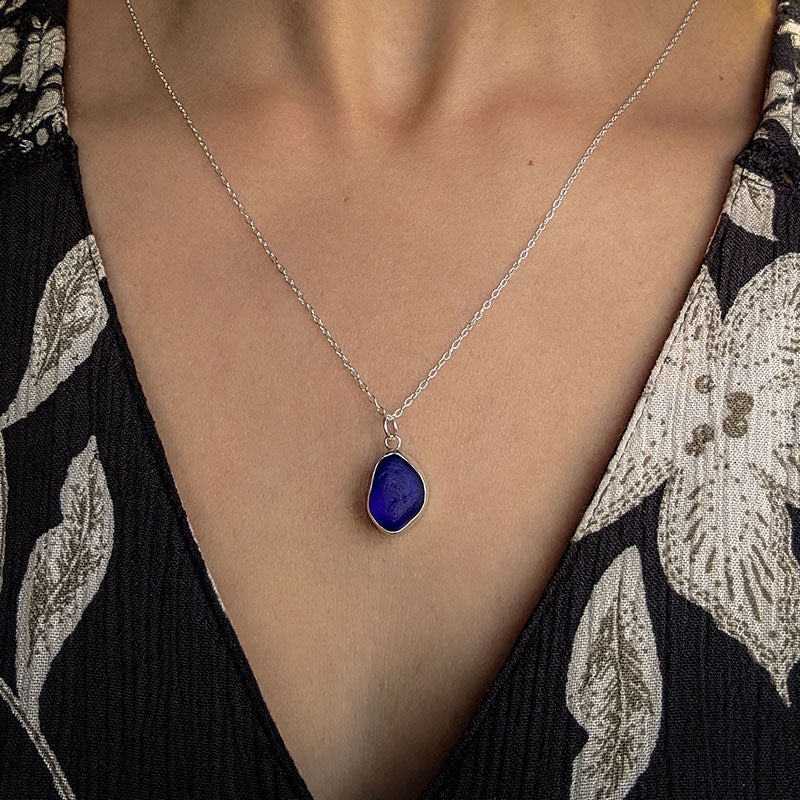 Cobalt blue sea glass necklace in sterling silver bezel setting, on woman's neckline