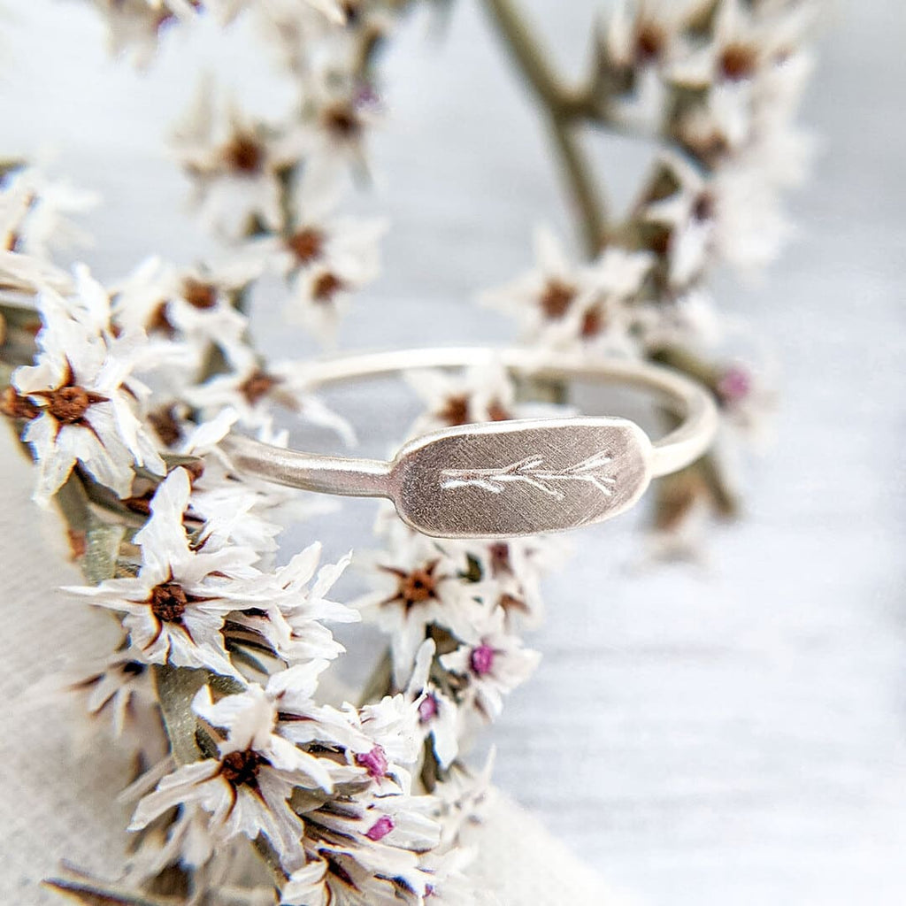 Sterling Silver Twig Ring: A close-up photo of a delicate ring featuring an embossed twig branch design, crafted from responsibly sourced and recycled silver.