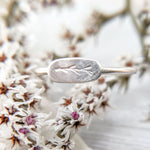 Sterling Silver Twig Ring: A close-up photo of a delicate ring featuring an embossed twig branch design, crafted from responsibly sourced and recycled silver.